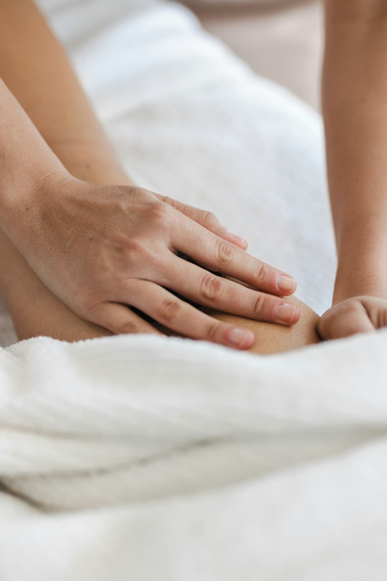 Hands resting gently on a soft white towel at the end of a session